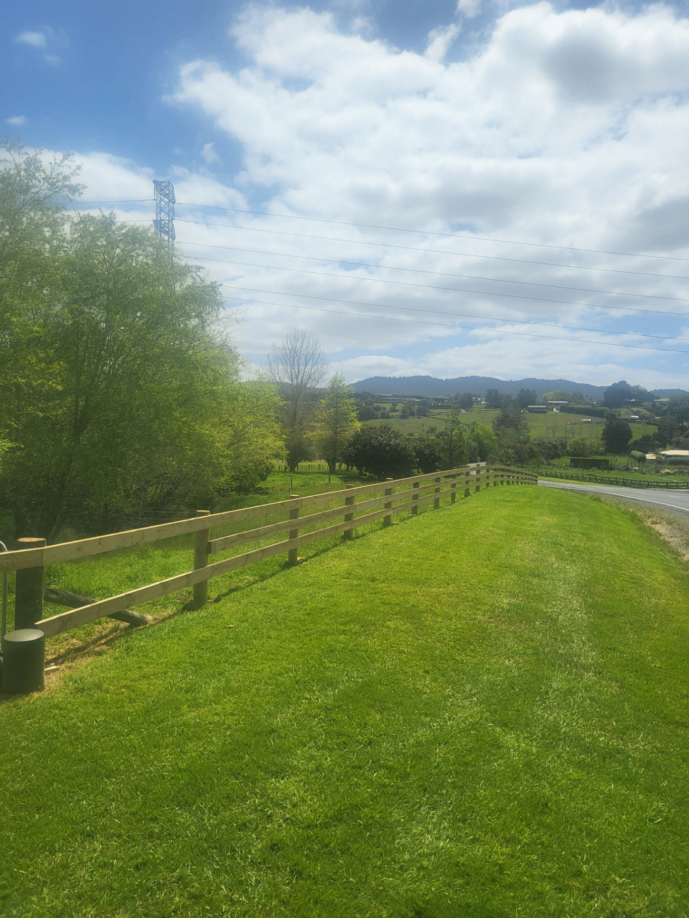 Post and rail timber fence along a rural roadside paddock