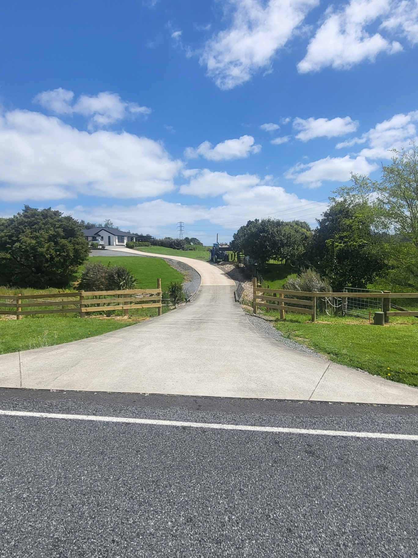 Timber post and rail fencing framing a rural property driveway
